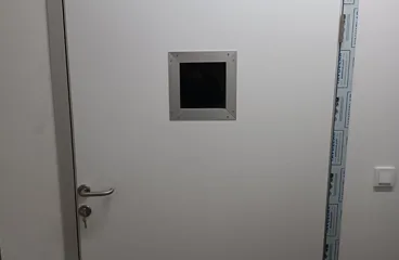 Kurşun kapı kanadındaki kurşun camlı gözetleme penceresinin yakın çekimi